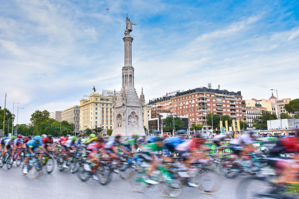 The cyclists peloton go through the colon plaza in madrid.