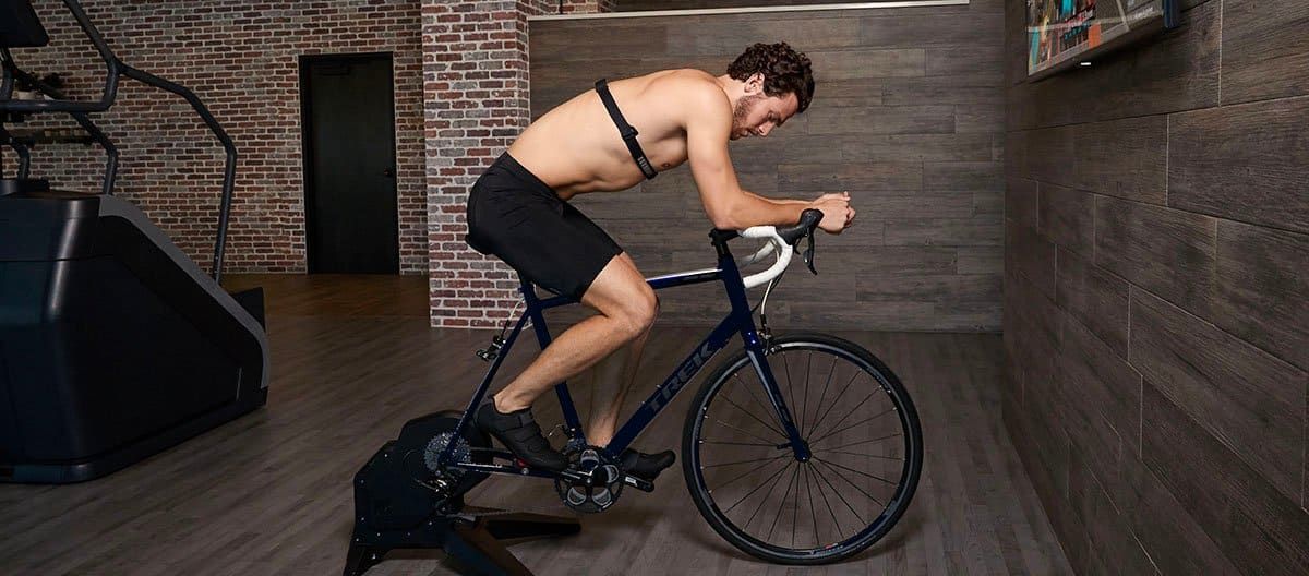 an indoor cyclist riding on the bike with HRM on his chest